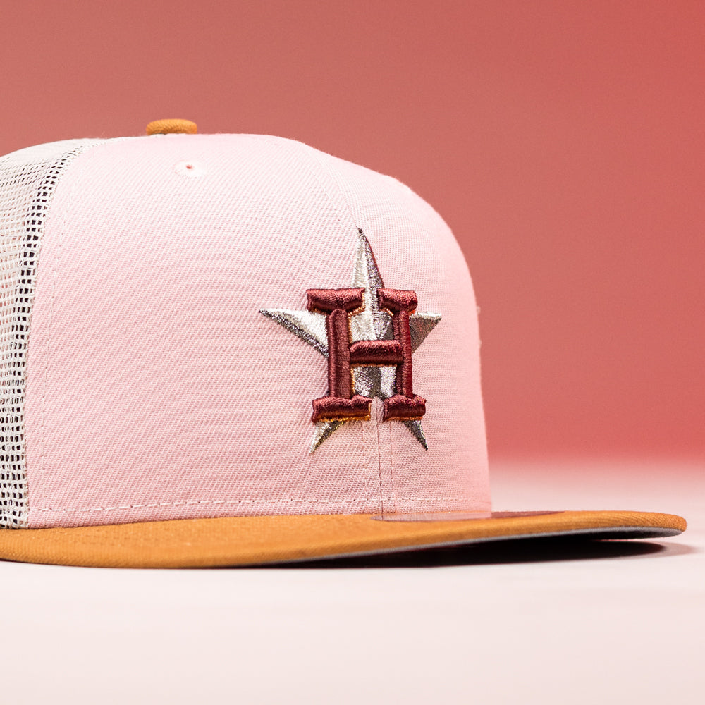 The Anglera 17WS Pink Trucker Houston Astros New Era Hat 5950 Fitted features a pink and white mesh design with a brown brim, embroidered star and H on the front, inspired by the Astros.
