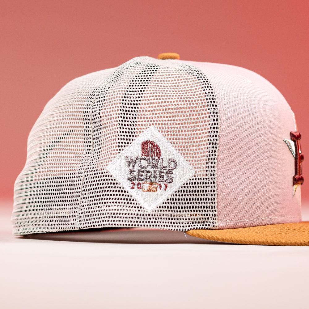 The Anglera 17WS Pink Trucker Houston Astros New Era 5950 Fitted features a pink and white mesh design, gold brim, and a diamond patch reading WORLD SERIES 2005 2017—an ideal pick for Astros fans.