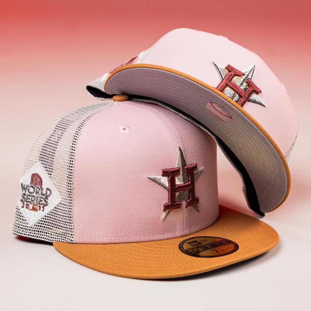 Two Anglera 17WS Pink Trucker Houston Astros New Era Hat 5950 Fitted caps with mesh backs, Astros logo, and 2021 World Series patch are shown on a pink gradient background.