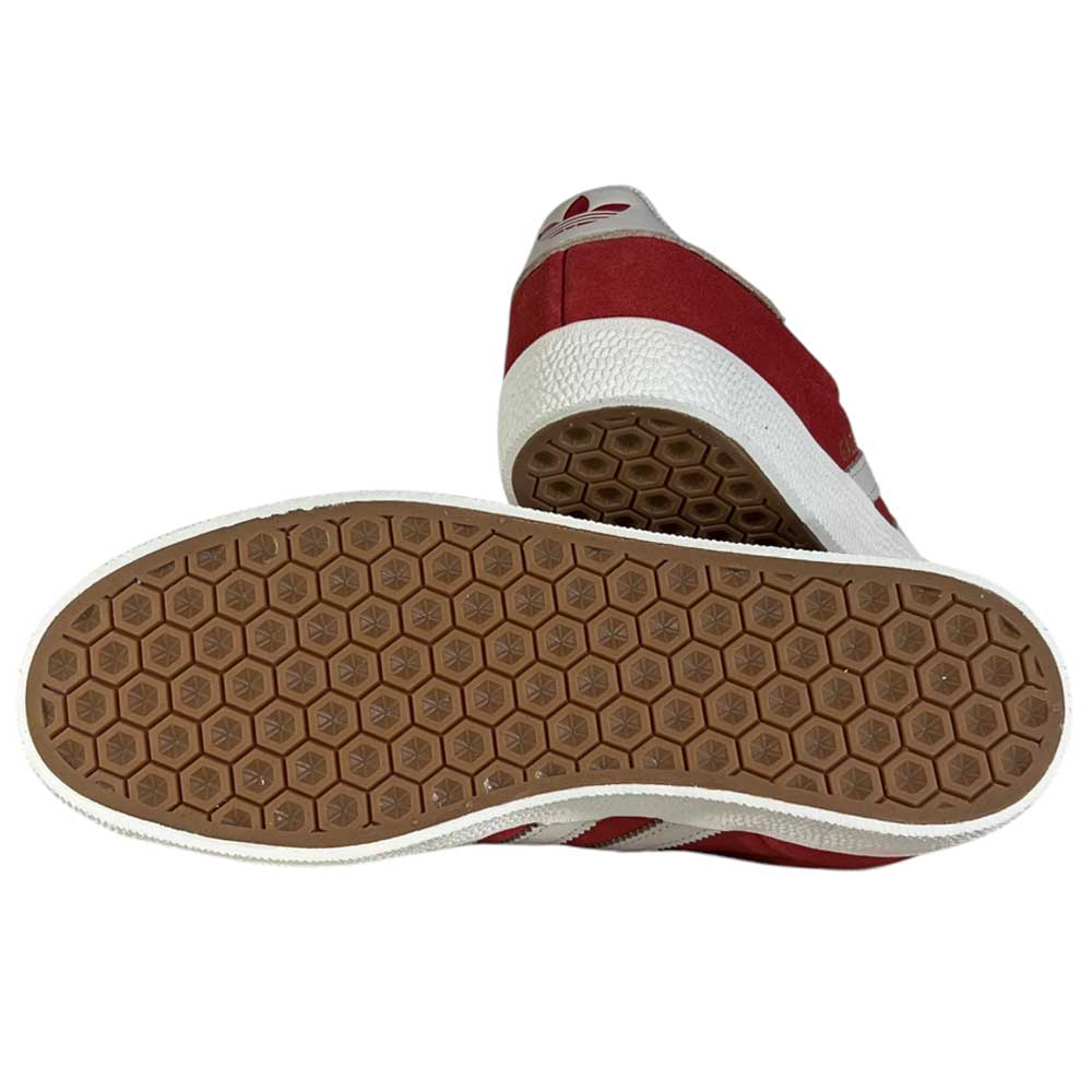 A pair of JP5861 Red White Gold Gazelle ADV Adidas Skateboarding suede shoes, one upright and the other showing a brown hexagonal sole pattern with small logos—classic skateboarding style.