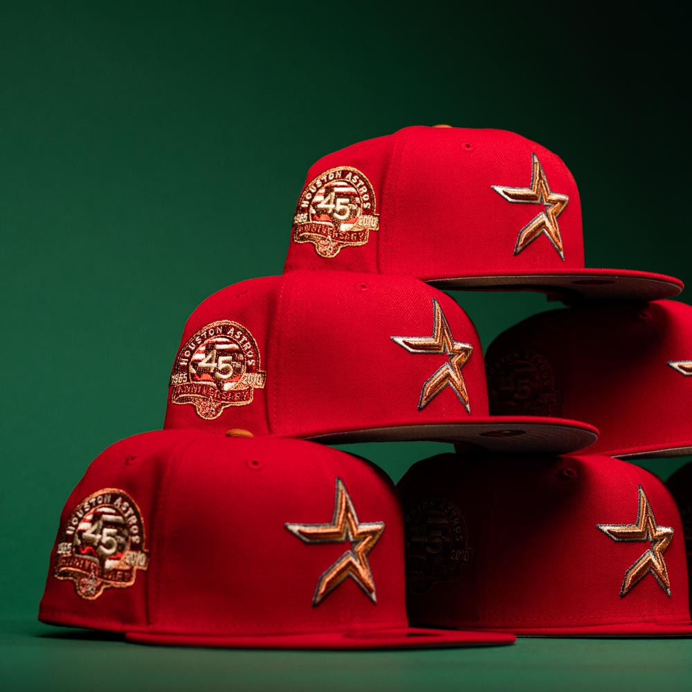 Six Rusty Screw OG Scarlet Copper Houston Astros New Era 5950 fitted hats, featuring gold star logos and a 45th Anniversary patch, are stacked against a green background.