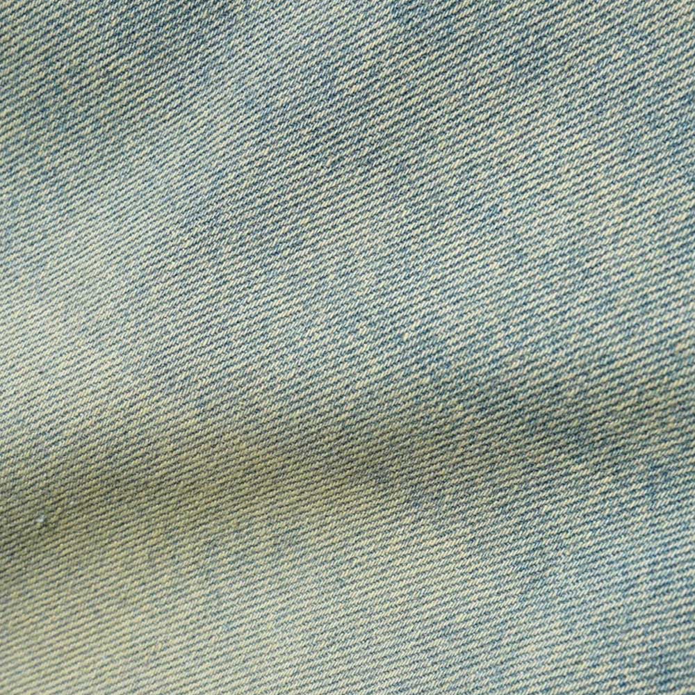 Close-up of the diagonal weave pattern on Scorpion Stitch Tinted Light Blue Denim Jeans by Butter Goods, featuring a subtle fold and shadow—ideal texture for stylish cotton or baggy fit denim jeans.