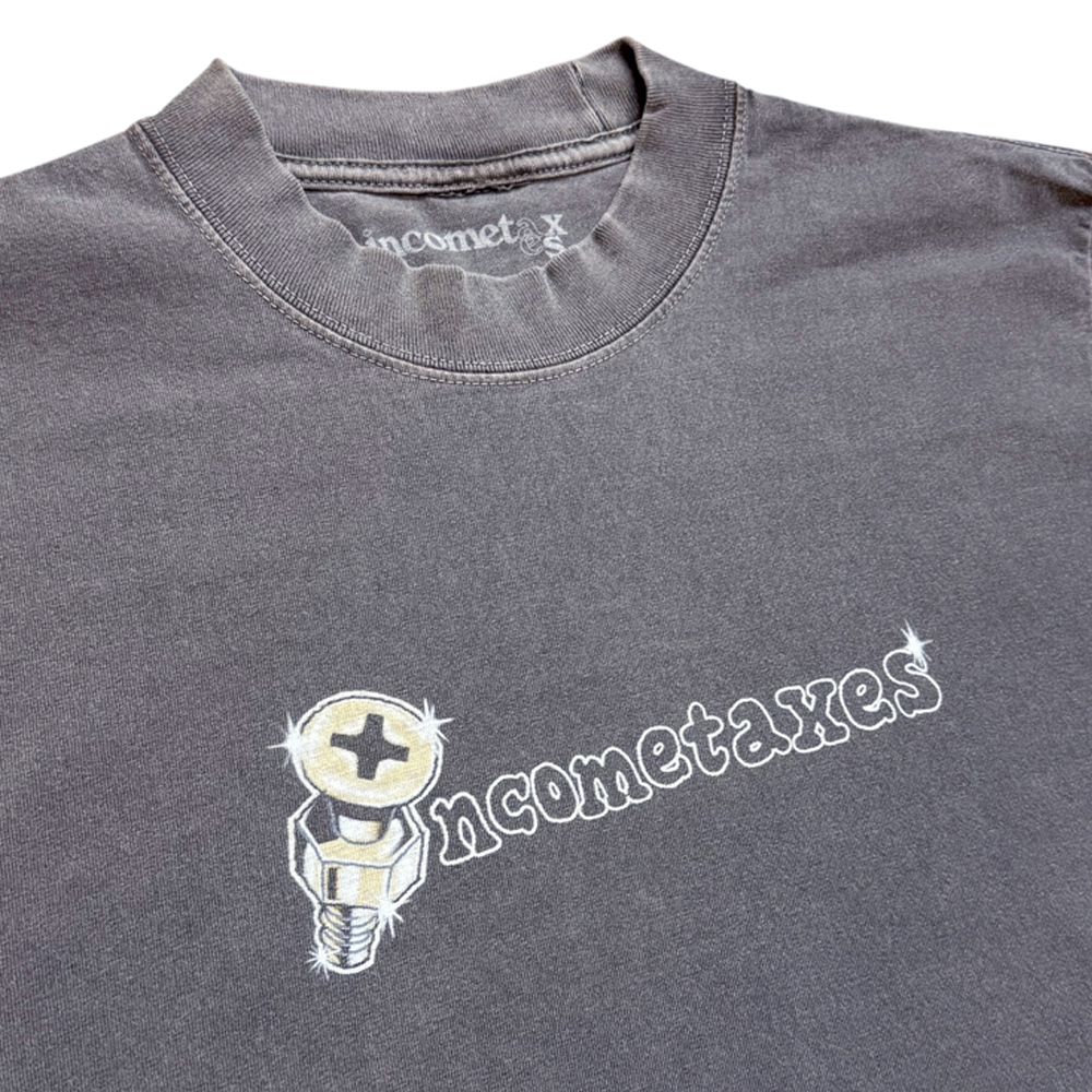 The Screw Head Tee Gray Income Taxes is a premium USA cotton t-shirt in gray, featuring "incometaxes" in white stylized text with a shiny screw graphic as the "o," inspired by local skateboarding culture for standout streetwear style.