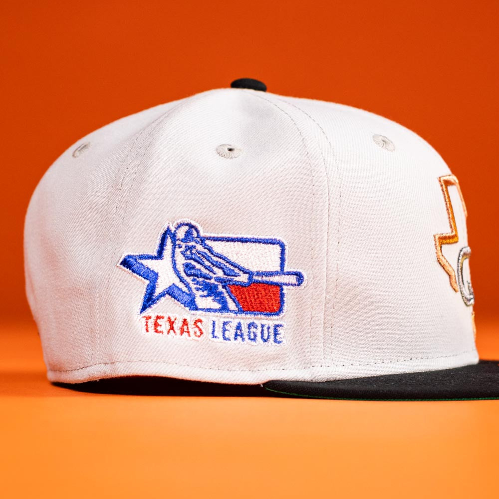 The Backlash Corpus Christi Hooks New Era 5950 Fitted Hat is a white cap with a black brim, showcasing an embroidered Texas League logo—a blue star, batter silhouette, and “TEXAS LEAGUE” text on an orange background.