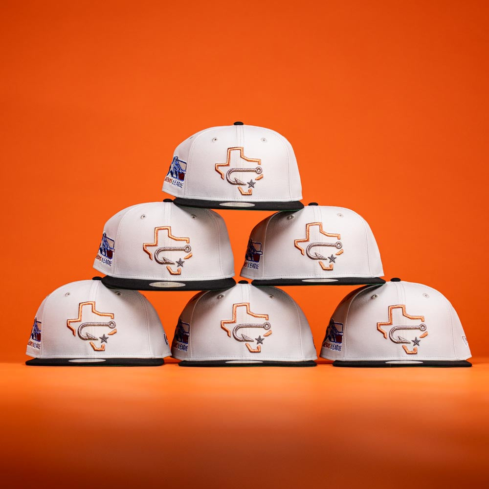 Six white Backlash Corpus Christi Hooks New Era 5950 Fitted hats with a Texas state outline and star logo are stacked in a pyramid on an orange background. Each hat has a side patch, black visor, and silver-black details.