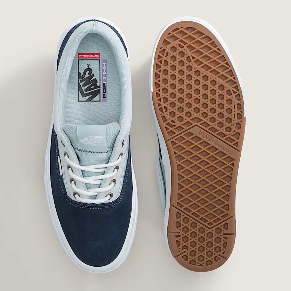 A pair of Vans Skate Era Wafflecup Navy Blue Bell VN000EF0J4I1 suede rubber shoes are shown from above, one displaying the light blue and navy upper with white laces, the other featuring the brown WaffleCup outsole with a signature waffle pattern.