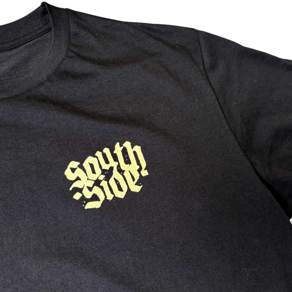 The Southside Support Your Local Skateshop Black Tee Skateshop Day features bold yellow gothic-style "South Side" lettering on the left chest, inspired by classic Brett Parson artwork.