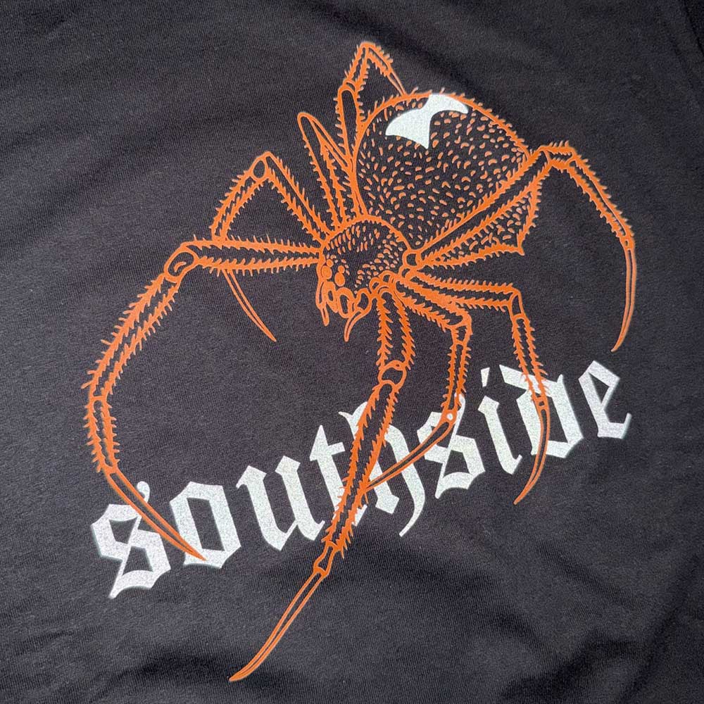 An orange spider graphic is printed over "southside" in bold white lettering on the black Southside YOUTH Tee Spider Black Orange Reflective, a sustainable Gildan Heavy Cotton t-shirt.