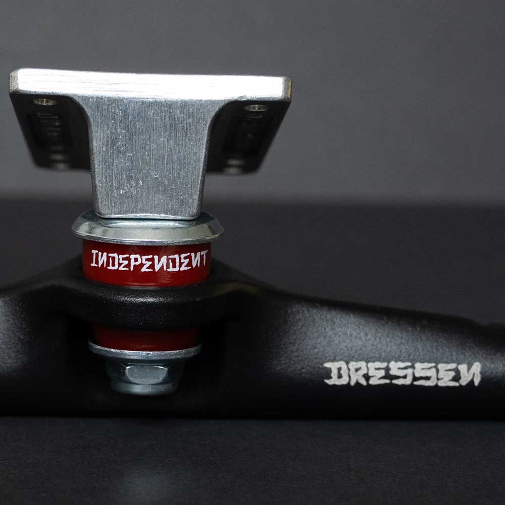 Close-up of Stage 4 Eric Dressen Pro 166 Black Silver Standard INDY Trucks (set of two) with a red INDEPENDENT bushing and DRESSEN text, set against a dark background.