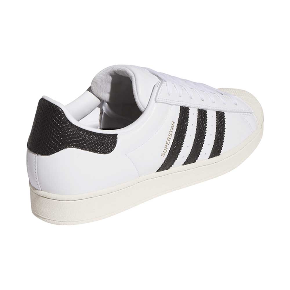 The Superstar ADV White Black KI5727 by Adidas features a white suede/leather upper, black stripes, a textured black heel, gold SUPERSTAR text, white sole, and rounded toe—perfect as a versatile skateboarding shoe.
