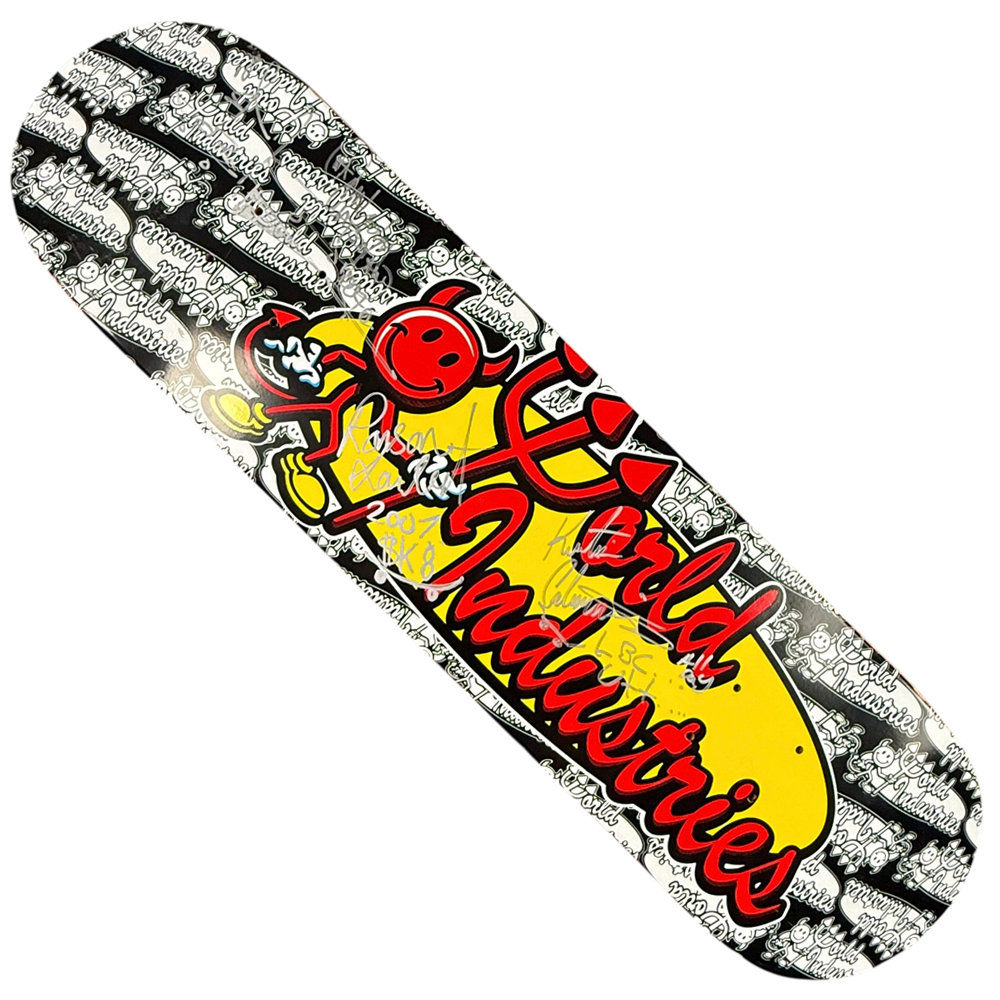 The Team World Industries Skateboards Deck 7.75x31.2 Circa 2007 Signed Collectible features a cartoon red devil with a yellow flame and bold red World Industries script, set against black and white graffiti-style logos.