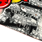 Close-up of a Team World Industries Skateboards Deck 7.75x31.2 Circa 2007, featuring black and white cartoon graphics and multiple silver marker autographs—a signed collectible.