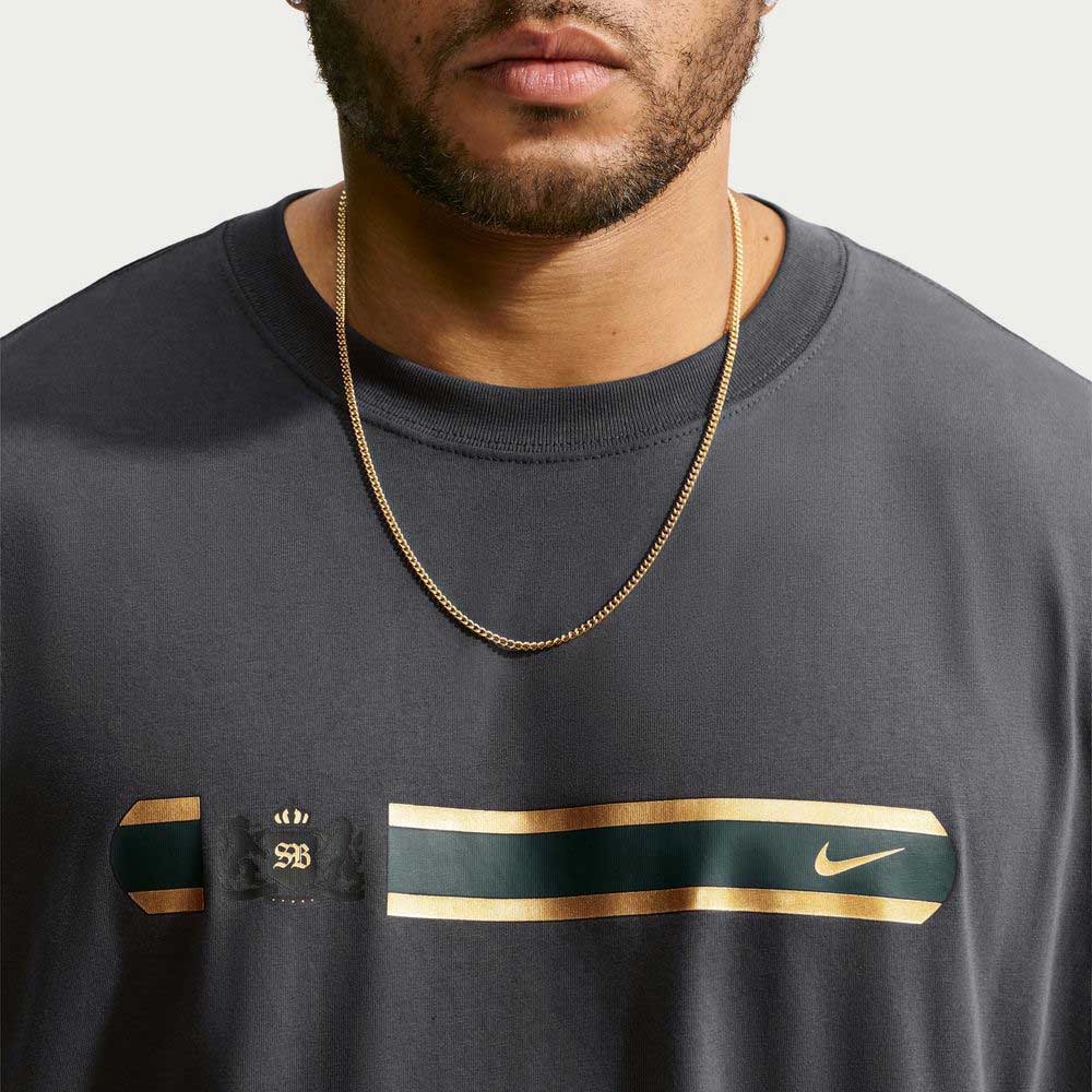Close-up of a person wearing a grey Tee Black IW3134060 T-Shirt Nike SB Skateboarding, featuring a horizontal chest band with a logo and a swoosh.