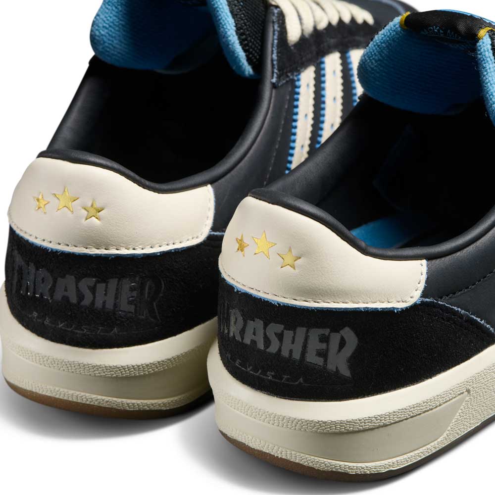 Close-up of the back of Thrasher Magazine Glenburn Black Blue KH7384 Adidas Skateboarding Shoes, showing gray THRASHER text and three yellow stars on the white leather heel tab, plus black, white, and blue adidas details.