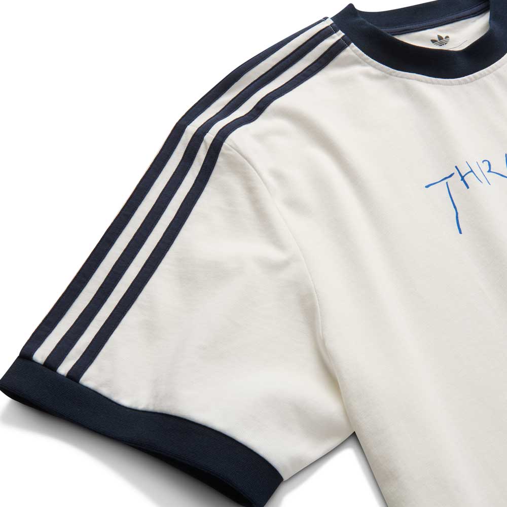 The Thrasher Magazine x Adidas AFA Tee White KX4548 by Adidas Skateboarding is a limited-edition white short-sleeve tee with black collar and sleeve trim, three black shoulder stripes, and blue chest embroidery.