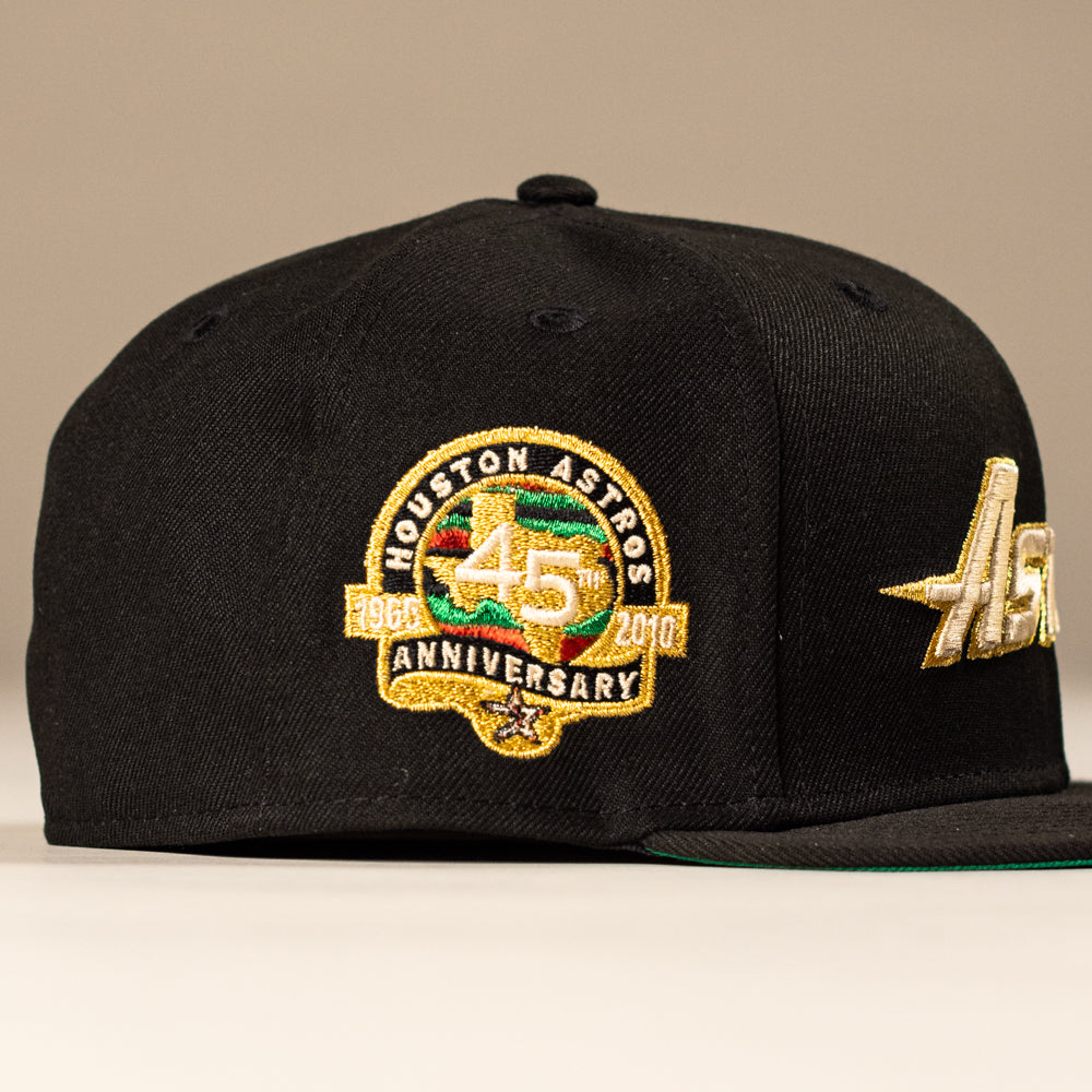 The La Morenita Black 45th Houston Astros New Era Hat 5950 Fitted features a gold Astros logo on the front and a gold and green embroidered 45th Anniversary 1962-2007 patch on the side.