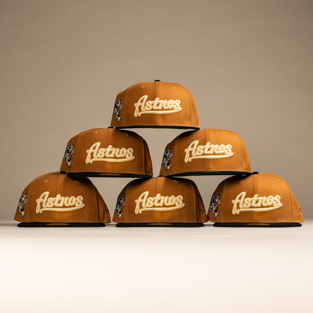 Six El Gallo Canvas Bronze Black Houston Astros New Era 5950 Fitted caps, each with front embroidery and side logo patches, are arranged in a pyramid shape on a neutral background.