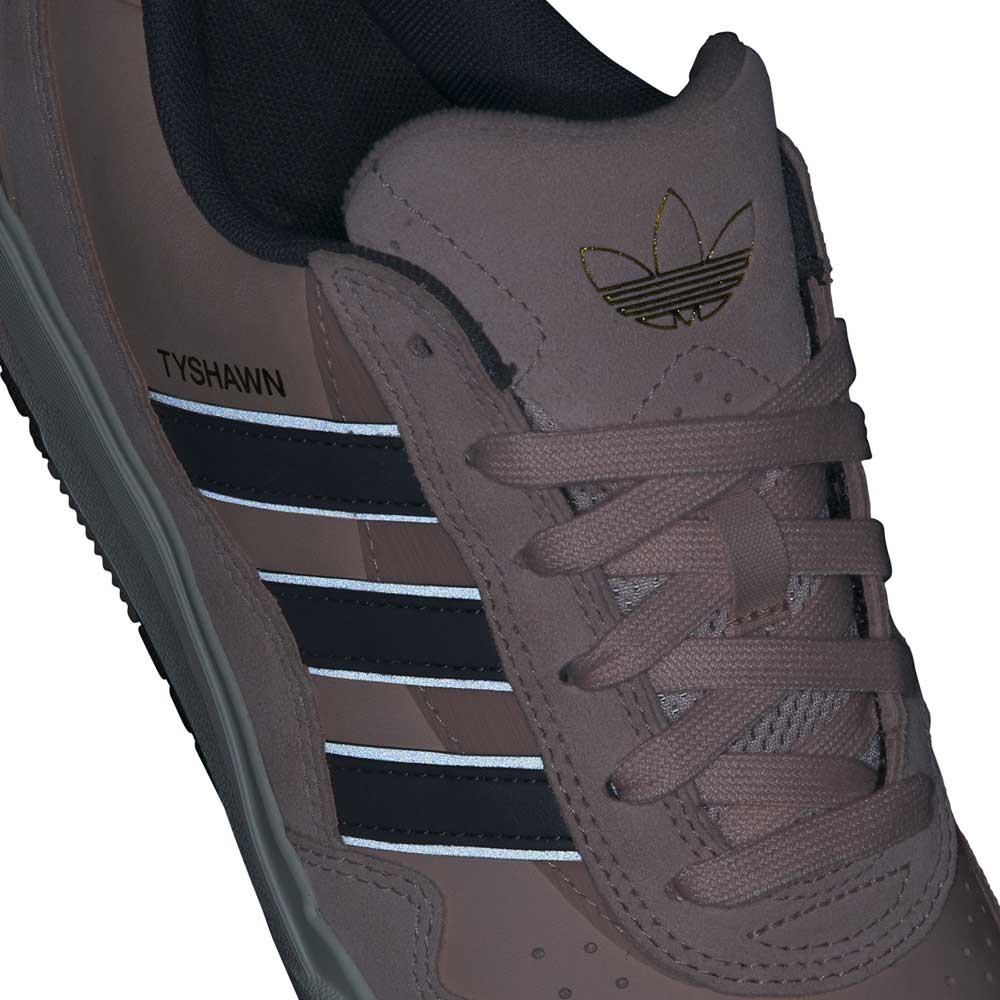 Close-up of the Tyshawn 2 II Pink Green HQ4733 Adidas skateboarding shoe featuring black and white stripes, "TYSHAWN" on the side, gold Adidas trefoil logo on the tongue, and light brown laces for a stylish finish.