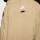 Close-up of the back pocket on the FV7347297 Kearny Cargo Pant Khaki Nike SB Skate Dri Fit, showing a black loop above the pocket and a white Nike SB logo printed above it.
