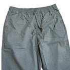 A pair of VN00000D1LE Range Baggy Tapered Taupe Pants from Vans Skateboarding, with an elastic waistband and side pockets, is laid flat on a white surface.