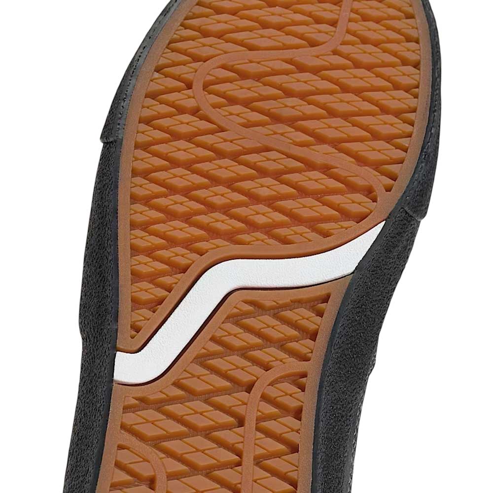 Close-up of the VN000D85CC81 Skate Curren Caples Charcoal Black Vans shoe’s brown suede rubber sole with wavy tread and curved white stripe, featuring black material and durable Duracap underlays for skating.