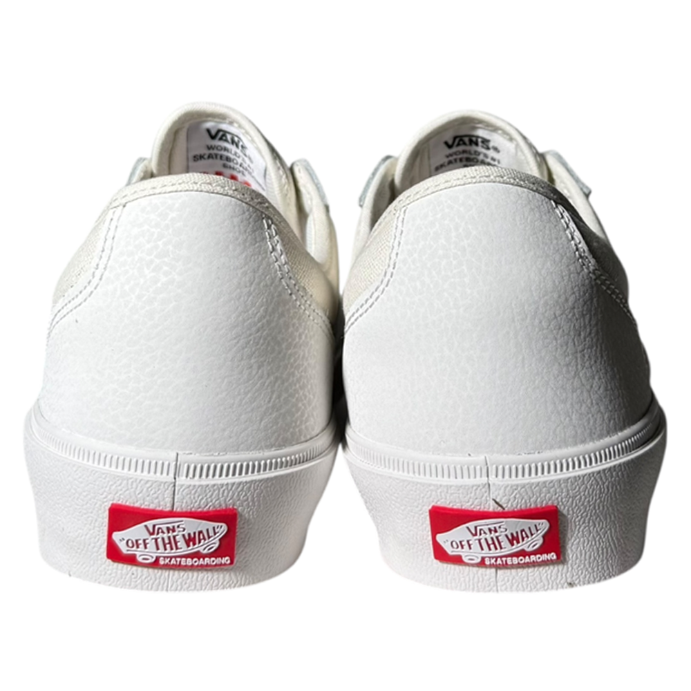 A pair of VN000D85JVY1 Skate Curren Caples Blanc de Blanc Vans Skate Suede Rubber Shoes in white, viewed from the back, feature textured suede and red Vans Off The Wall logos on the heels—classic vulcanized shoes for style and performance.