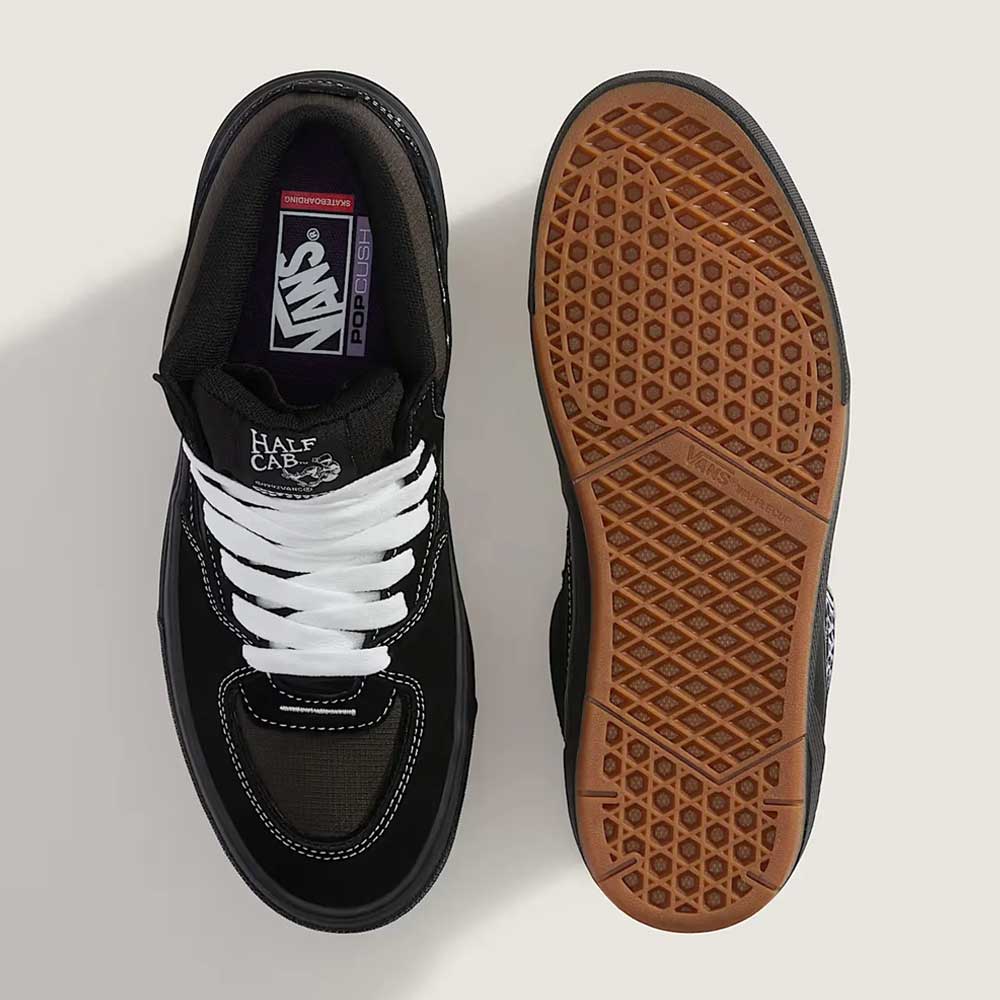 A pair of VN000D9ZKOU Black Asphalt Suede Skate Wafflecup Half Cab Vans Shoes is shown from above; one displays the top with white laces, the other shows the brown Wafflecup-patterned sole.