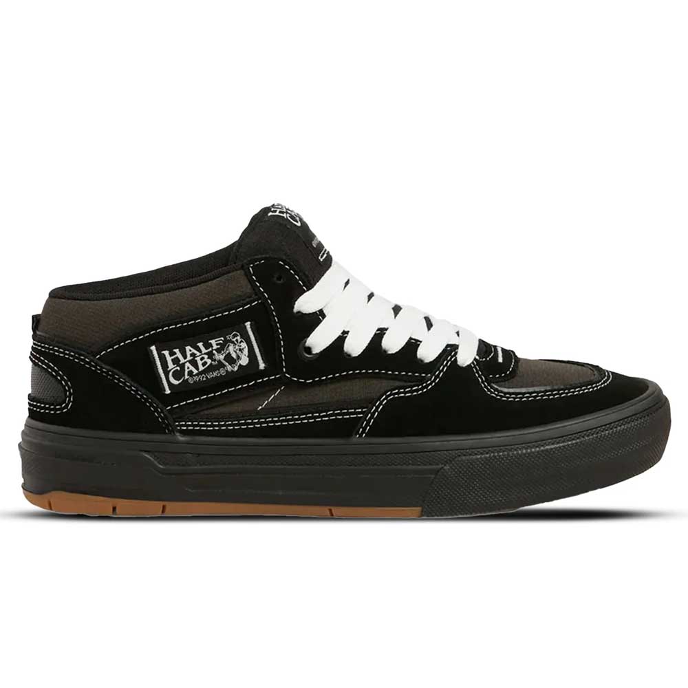 The VN000D9ZKOU Black Asphalt Suede Skate Wafflecup Half Cab Vans features white stitching and laces, a black mid-top upper, brown sole accents, a Half Cab side patch, and a durable Wafflecup sole for excellent boardfeel.