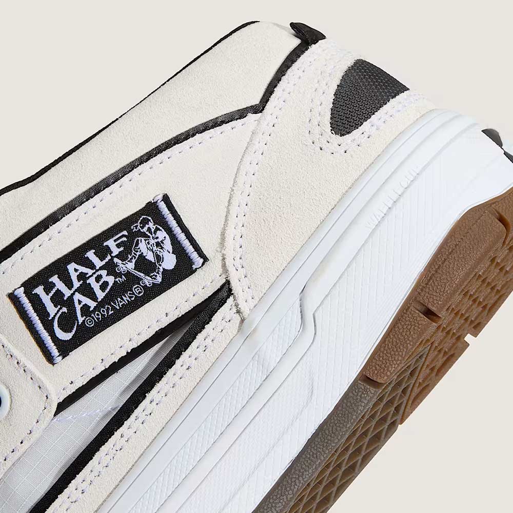 Close-up of the VN000D9ZYB2 White Black Suede Skate Wafflecup Half Cab Vans Shoes, featuring detailed stitching, the Half Cab logo side label with skateboard graphic, and signature Wafflecup textured sole.