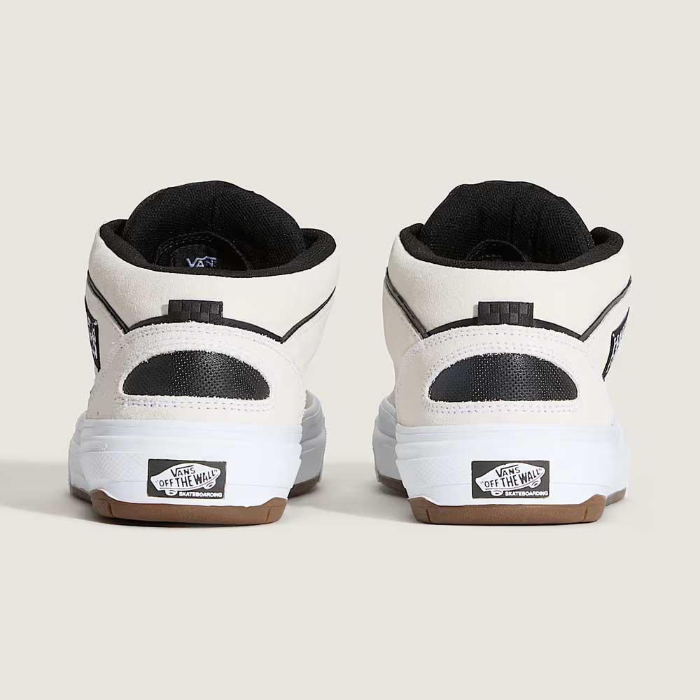 A pair of VN000D9ZYB2 White Black Suede Skate Wafflecup Half Cab Vans shoes shown from the back with black trim, black interior lining, and the Vans Off The Wall logo on the heels. Set against a plain light beige background.