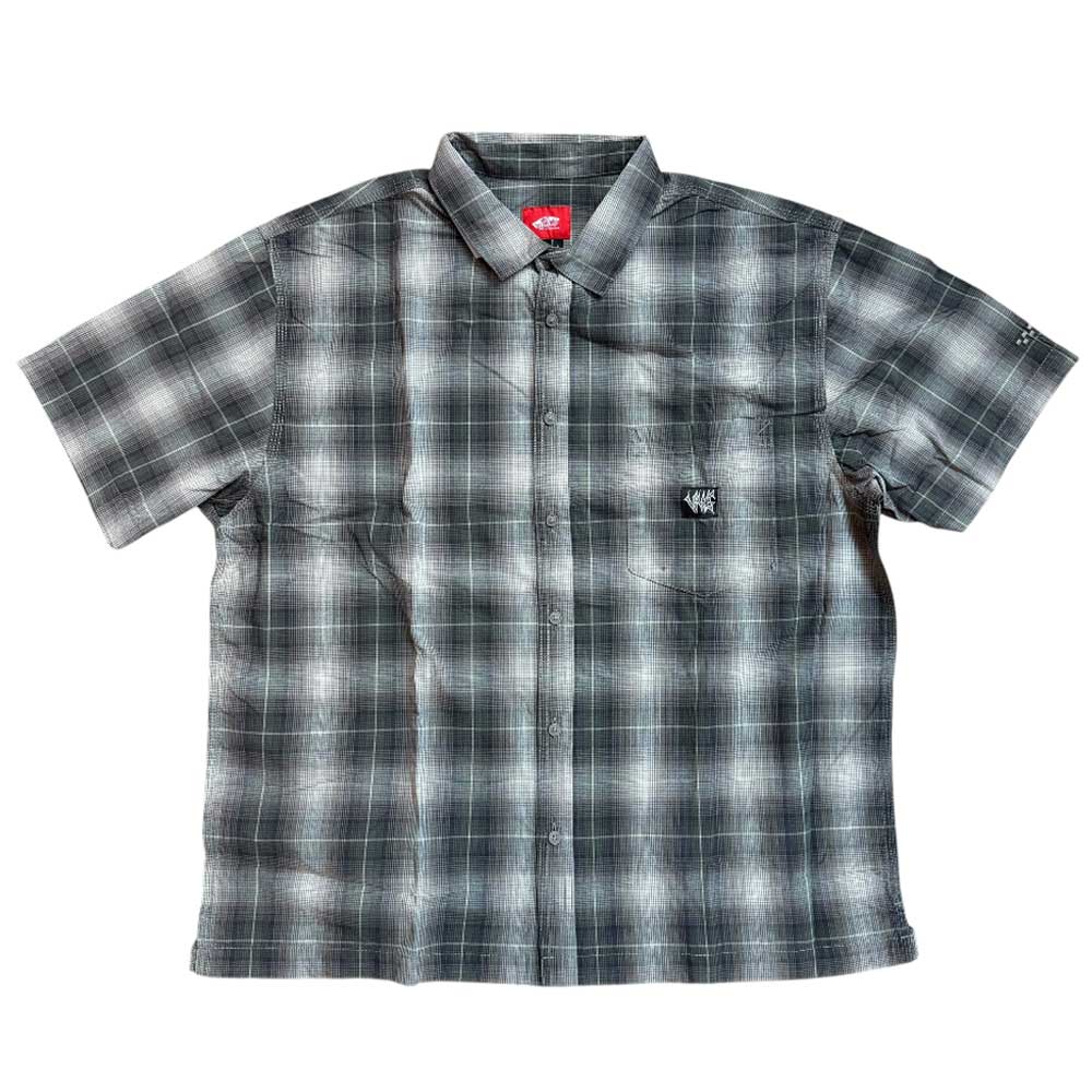 The VN000KYW1NU1 Walnut Skate Plaid SS Woven Top by Vans features short sleeves, a black, white, and gray plaid pattern, chest pocket, and embroidered logo. Displayed flat on a white background.