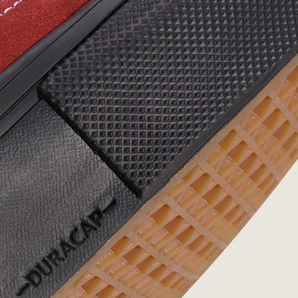 Close-up of the Vans Authentic Mid VN000EEQGWR1 Poppy Ember Red Suede Skateboard Shoes sole with textured black vulcanized rubber outsole, tan waffle-patterned tread, and DURACAP embossed—designed for skateboarding.