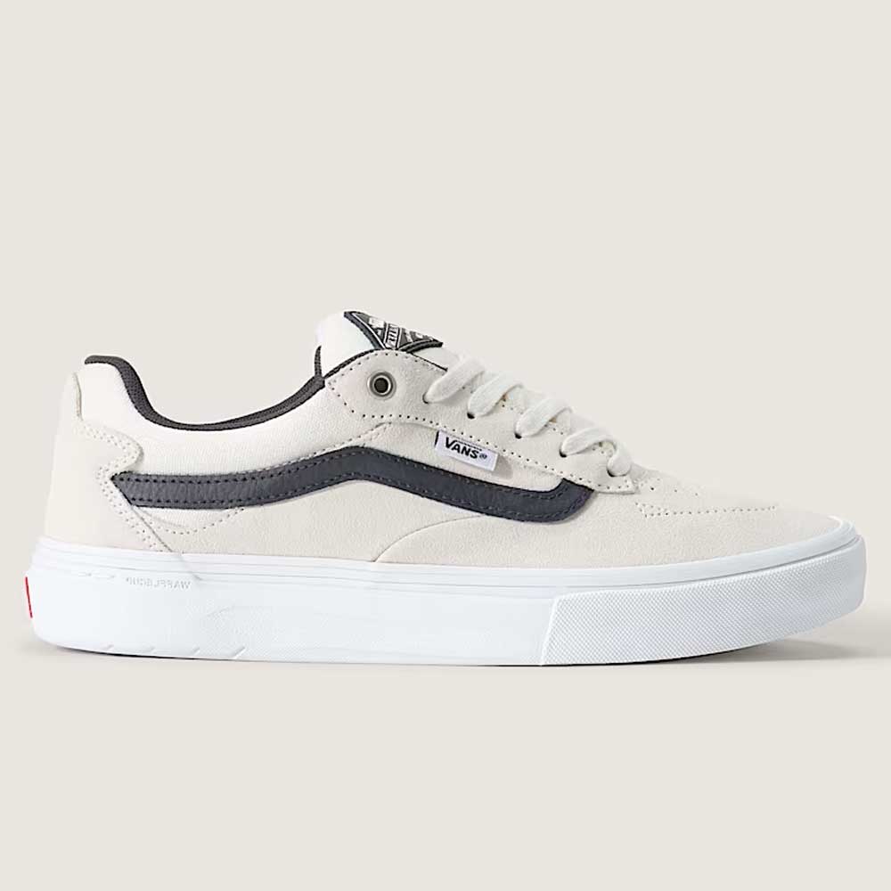 The Vans Skate Kyle Walker Wafflecup White Gunmetal VN000DA4XQL1 Suede Rubber Shoes are beige skate shoes designed in collaboration with Kyle Walker, featuring a black stripe, white sole, and black detailing. Displayed from the side against a plain light background, this model incorporates PopCush technology for enhanced comfort and impact protection.