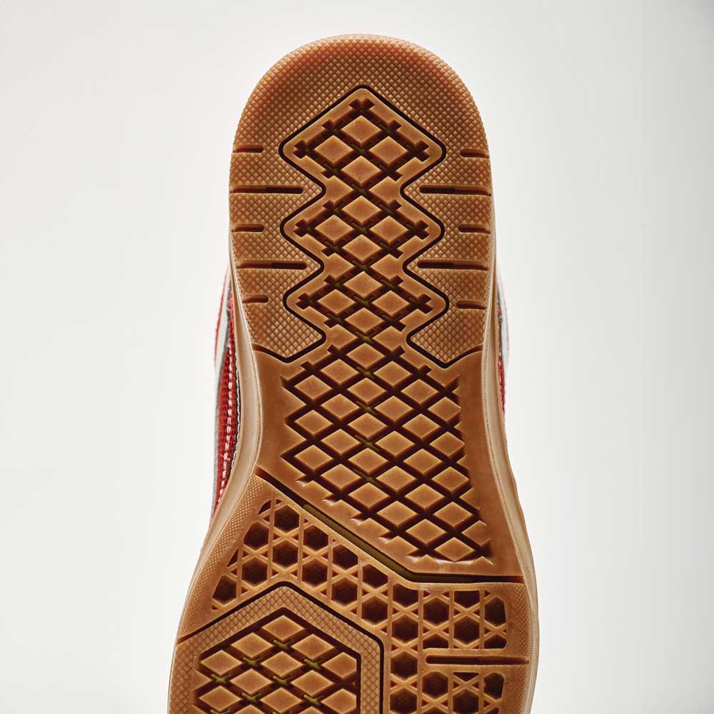 Close-up of the Vans Skate Rowan Z3 VN000V74BRD Gum Bordeaux Suede shoe's sole, showing gum-colored rubber with geometric tread for grip and impact protection; red and white upper edge visible.