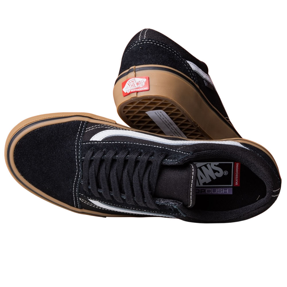 A pair of Vans Skate Old Skool Black Gum White VN000EDNB9K1 suede rubber shoes—one lies on its side revealing the gum sole, while the other stands upright with visible laces and logo on the tongue.