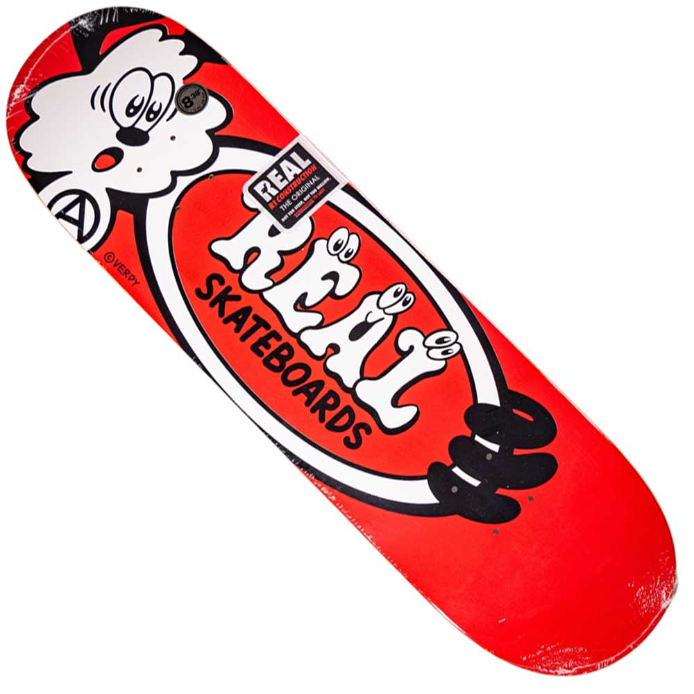 The Verdy Oval 8.38 Real Skateboard Deck Skateshop Day features a vibrant red design with the “REAL Skateboards” logo in white, bold black outlines, a playful cartoon face, and striking black and white graphic details.