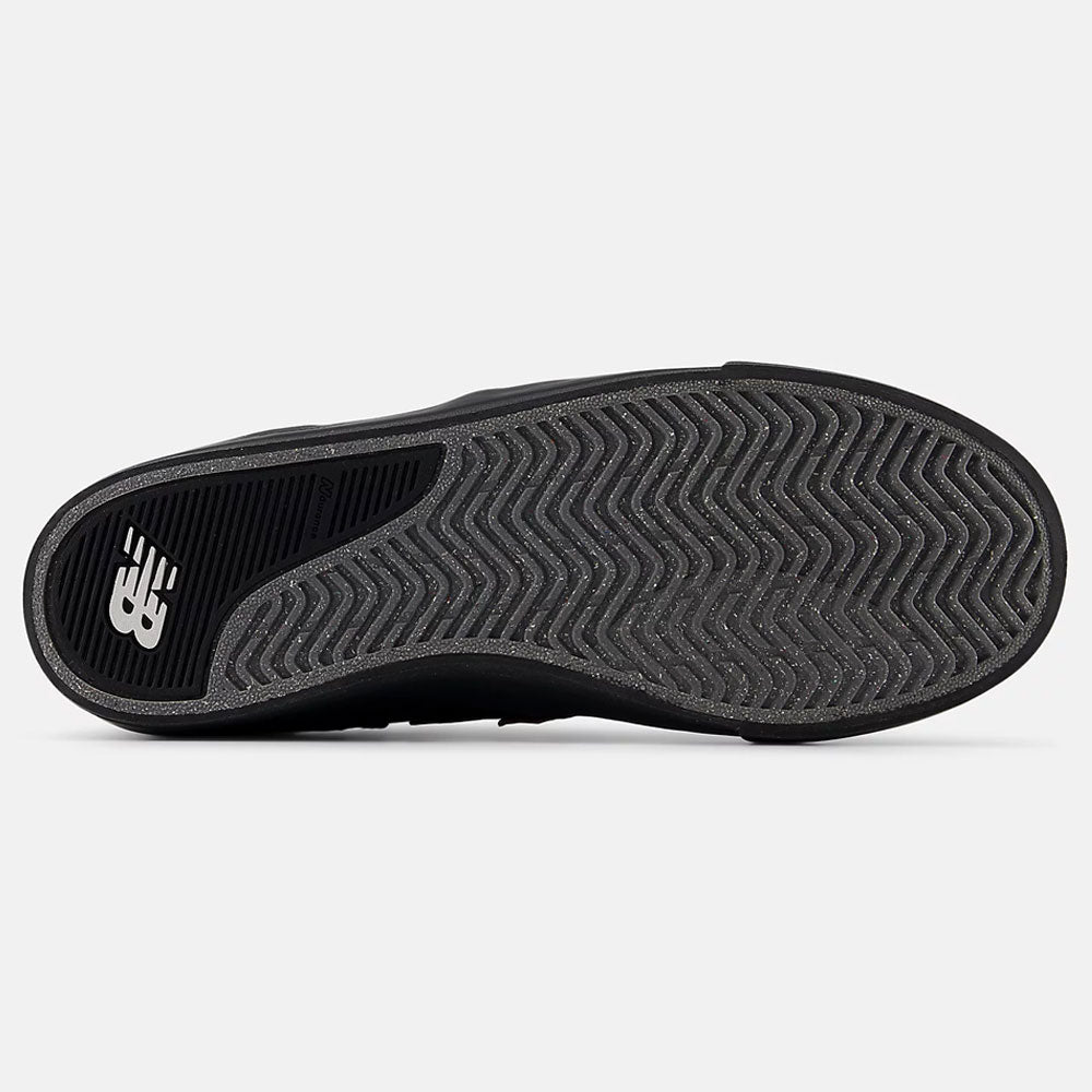 The image displays the bottom view of the White Black 306 BON New Balance Numeric Suede Skateboarding Shoe, featuring a black sole with a herringbone pattern and NB logo on the heel, inspired by Jamie Foy’s pro model design.