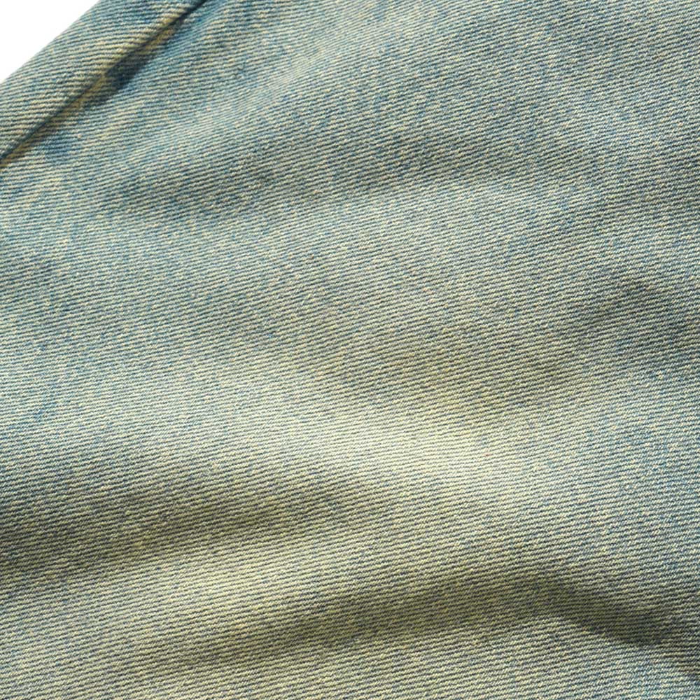 Close-up of Tinted Blue Wash Denim fabric, showcasing its texture and diagonal weave in the Wide Cut Tinted Blue Wash Denim Jeans by Butter Goods. Subtle wear and gentle fading enhance the authentic look.