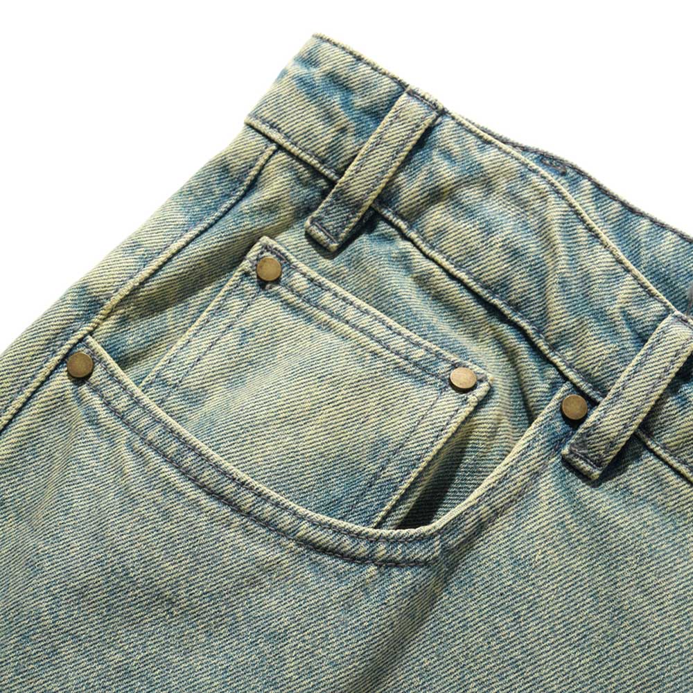 Close-up of the front pocket area of Wide Cut Tinted Blue Wash Denim Jeans by Butter Goods, featuring a small coin pocket inside the main pocket, metal rivets, and belt loops.