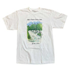 The World Famous Lennox Ledges Tee by Quartersnacks in white features an illustrated park scene with trees and paths, plus text reading “World Famous Lenox Lodge” above and “Harlem, U.S.A.” below.