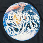 A stylized image of Earth from space features swirling clouds that spell “UNNATURAL ACTS”—the perfect highlight on the World Tee Black Late Nite Stars Screenprinted.