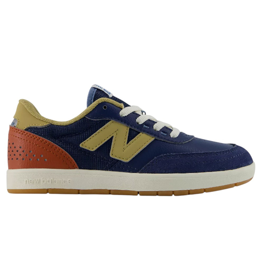 The YOUTH 440 NVB New Balance Numeric Suede Skateboarding Shoes feature a navy blue upper with a tan “N” logo, tan heel and lining, perforated reddish-brown heel patch, white laces, and a durable tan rubber cupsole. Designed for skating, this model also includes a reinforced toe cap for extra durability, making it an ideal choice for those seeking classic style and lasting performance in youth skate shoes.