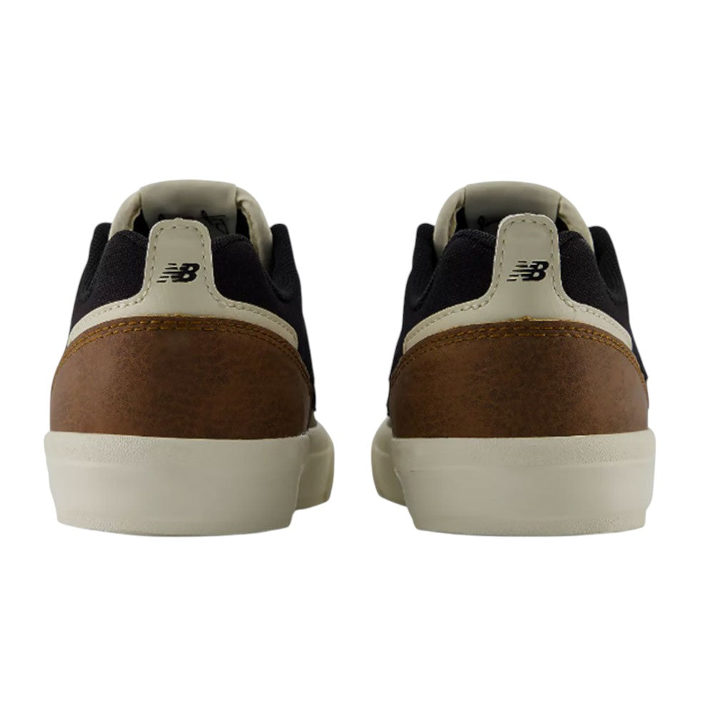 Back view of the YOUTH Jamie Foy Cup 306 TWY New Balance Numeric Suede Skateboarding Shoes, featuring black uppers, tan leather heel accents, beige soles, and the iconic New Balance logo on the heel tabs—a stylish kids’ skate shoe inspired by Jamie Foy.