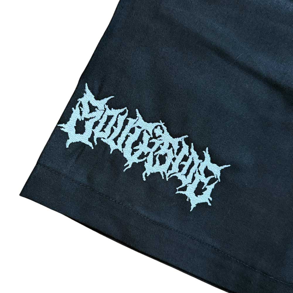 A close-up of black fabric from the YOUTH Texas Icon Black Southside 94 Shorts features light blue, spiky, stylized embroidery spelling EMOTIONS near the hem.