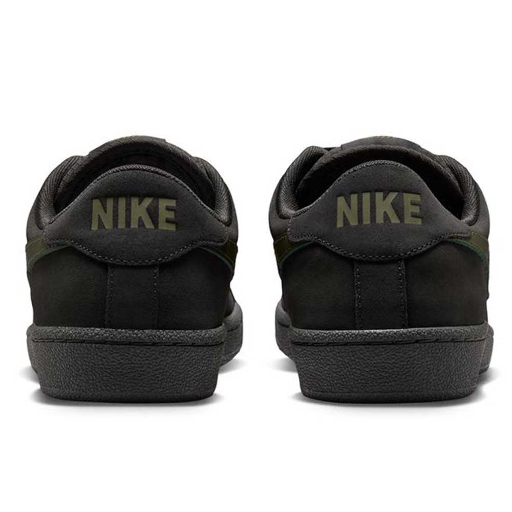 A pair of Zoom Tennis Classic HF7386200 Deep Pewter Medium Olive Suede Nike SB skateboarding shoes viewed from the back, each heel displaying NIKE in capital letters and featuring a comfortable Solarsoft insole.