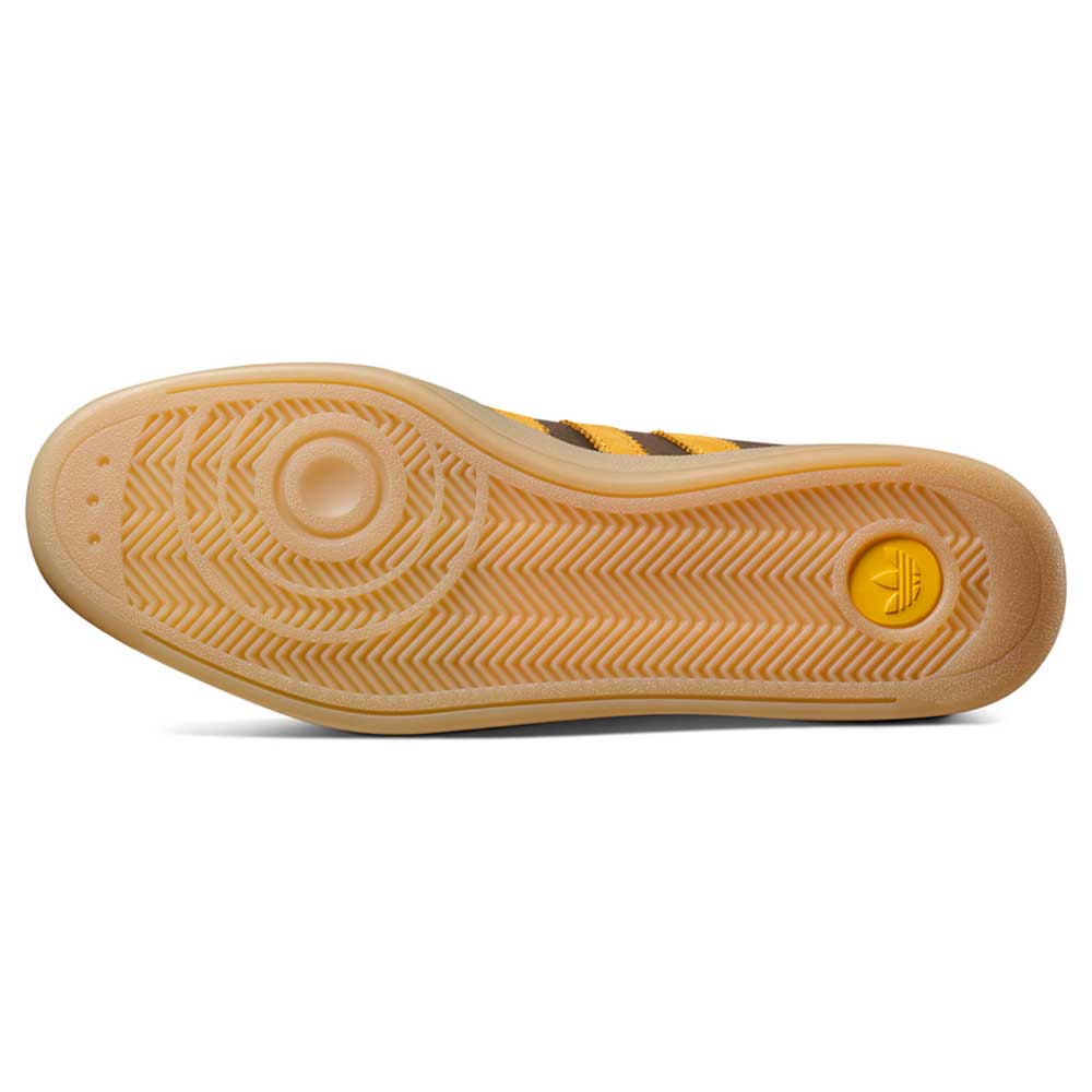 The image features the bottom sole of the Daewon Song Glenburn Brown Yellow KZ8777 Adidas Skateboarding Shoes, displaying a yellow and brown herringbone tread pattern with circular designs, characteristic of street style sneakers made for both fashion and function.