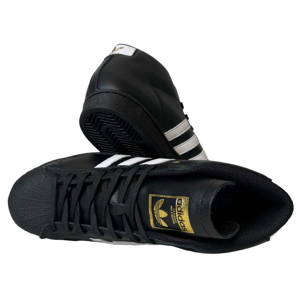 A pair of Adidas Pro Model ADV Black White Gold Leather Shoes, featuring white stripes and gold branding: one stands upright displaying the side, while the other lies on its side showing the sole and top. Stylish and classic, they're iconic skateboarding shoes.