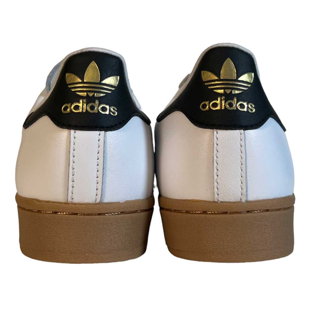 Back view of Adidas Superstar ADV White Black Gum Leather Shoes—white leather sneakers with brown gum soles, black heel tabs, and gold Adidas trefoil logo, offering timeless style for skateboarding.