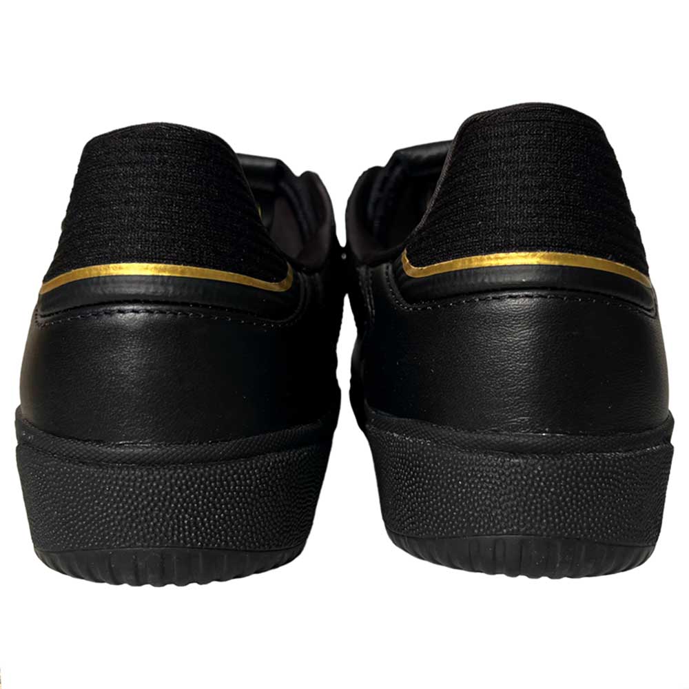 A pair of Tyshawn Low Adidas Skateboarding Black White Leather Suede Shoes viewed from the back, with a thin gold stripe near the heel and textured rubber soles—the perfect skate footwear.