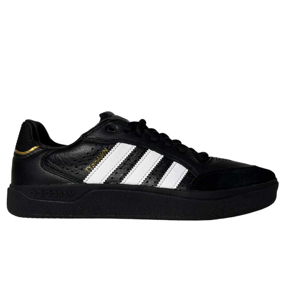 The Tyshawn Low Adidas Skateboarding Shoes feature black leather and suede with white stripes, a black sole, and gold detail near the heel—shown side-on against a white background for stylish skate appeal.